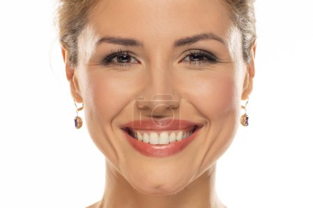 Téléchargez les photos : Portrait d'une femme joyeuse avec un beau sourire et un maquillage de bon goût, révélant ses dents naturellement blanches et saines, exprimant bonheur et confiance - en image libre de droit