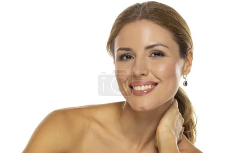 Téléchargez les photos : Portrait d'une femme joyeuse avec un beau sourire et un maquillage de bon goût, posant sur fond de studio blanc, exprimant bonheur et confiance - en image libre de droit