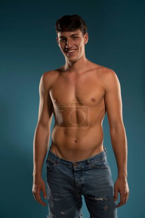 Photo for Young smiling athletic guy. concept: the male body after exercise and diet. men's health. Blue studio background - Royalty Free Image