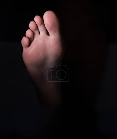 Foto de Suela y dedos del pie femenino sobre un fondo negro de estudio - Imagen libre de derechos