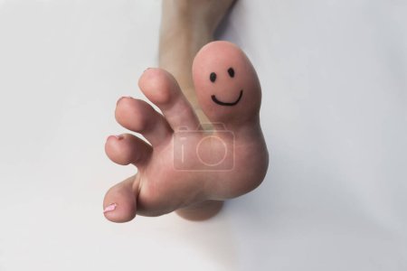 Photo for Closeup of a female toes with a smile drawn on them - Royalty Free Image