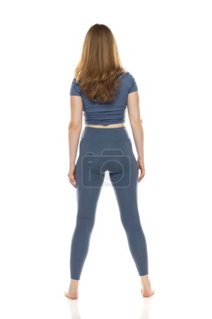 Photo for Full body, back view young woman in sportswear posing on white studio background - Royalty Free Image