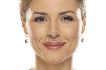Téléchargez les photos : Portrait d'une belle femme souriante avec maquillage sur fond de studio blanc - en image libre de droit