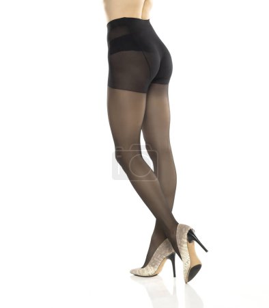 Foto de Mujer con hermosas piernas largas, medias negras y tacones altos, aislada sobre fondo blanco estudio. Vista trasera - Imagen libre de derechos