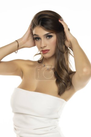 Foto de Retrato de hermosa mujer morena sensual elegante con vestido blanco de moda aislado sobre fondo de estudio blanco - Imagen libre de derechos