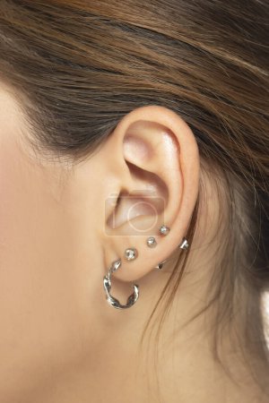 Photo for Closeup of female ear with four piercings - Royalty Free Image
