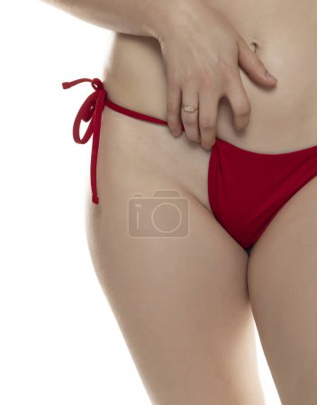 Foto de Mujer con bragas rojas mostrando su área púbica encerada sobre fondo blanco del estudio - Imagen libre de derechos