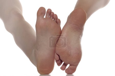 Photo for Sole feet of two different woman on a white studio background - Royalty Free Image