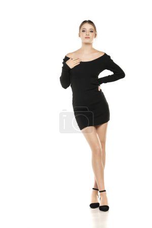 Photo for Summer Chic: Full-Length Portrait of a Young Woman Posing in a Short Dress and Sandals on White Studio Background - Royalty Free Image