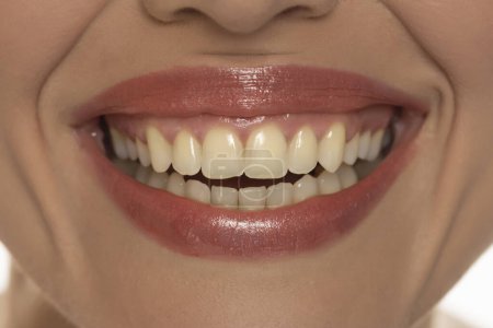 Foto de Primer plano de la boca de una mujer, capturando una sonrisa segura y perfectos dientes y labios naturales. - Imagen libre de derechos