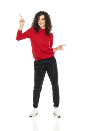 Photo for Young curly happy woman dancing on white studio background. - Royalty Free Image