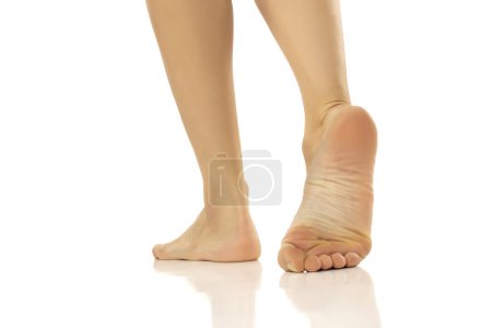Foto de Primer plano de pies desnudos femeninos de pie sobre fondo blanco del estudio - Imagen libre de derechos