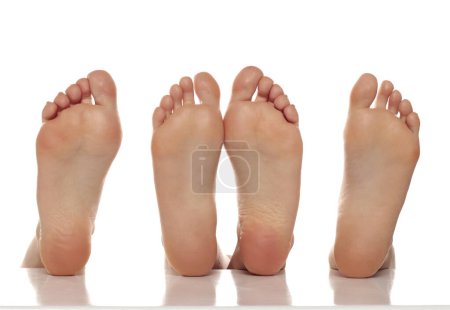 Photo for Two pairs od a beautiful well-groomed women's sole feet close-up on a white isolated studio background, The concept of foot skin care - Royalty Free Image