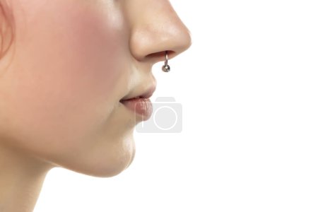 Téléchargez les photos : Gros plan du visage d'une jeune femme sérieuse avec un septum perçant accroché à son nez. Voeu latéral - en image libre de droit