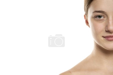 Photo for Half portrait of a beautifu smilingl young women with tied hair and no makeup on a white studio background. - Royalty Free Image