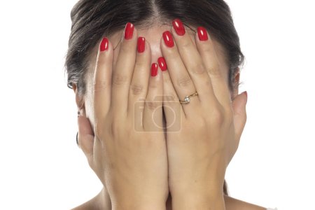 Photo for Woman covering face with hands on a white studio background - Royalty Free Image