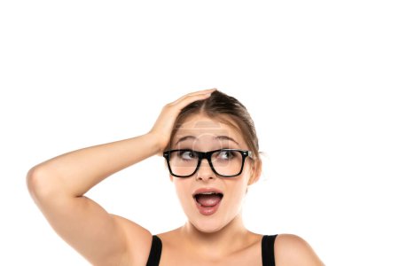 Expressive Beauty: Portrait of a Surprised Young Woman with Makeup and Glasses, Updo, Holding Head and Raised Eyebrows on White Studio Background