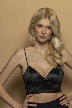 Foto de Retrato de belleza de la joven modelo de moda con pelo largo y rubio sobre fondo beige estudio - Imagen libre de derechos