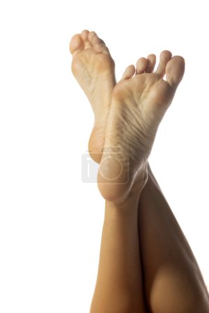 Téléchargez les photos : Les pieds nus de la belle femme sur un fond de studio blanc avec copyspace - en image libre de droit