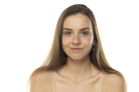 Foto de Retrato de una joven adolescente sonriente sin maquillaje sobre un fondo de estudio blanco - Imagen libre de derechos