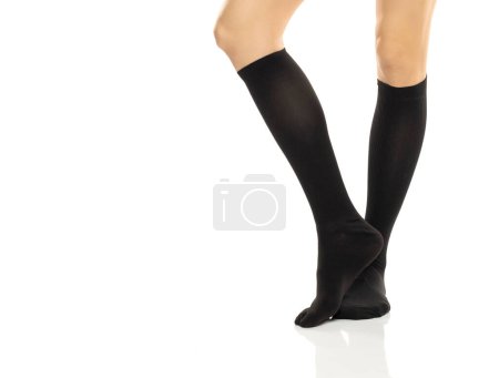 Téléchargez les photos : Jambes féminines en compression Hosiery. Bas médicaux, collants, chaussettes, mollets et manches pour les varices et la thérapie veineuse. Tricot clinique. Chaussette de sport isolée sur fond de studio blanc - en image libre de droit