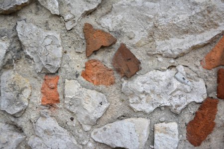 Fragment of old stone and brick  wall. Rough textured surface. Wall of old house