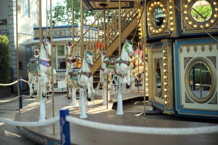 Téléchargez les photos : Motioned blurred picture of horse of the carousel with defocused horses and bokeh lights in background. - en image libre de droit