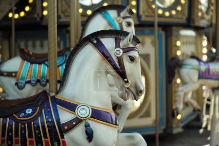 Téléchargez les photos : Motioned blurred picture of horse of the carousel with defocused horses and bokeh lights in background. - en image libre de droit