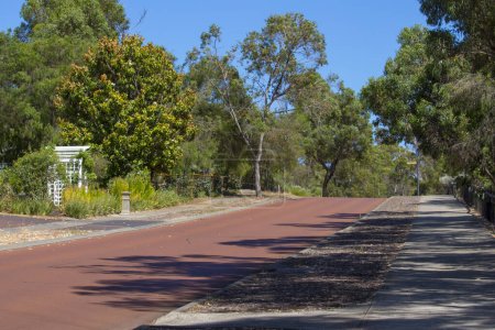 Street View of hilly Maidment Parade, Dalyellup, Australie-Occidentale avec le cyclisme, adjacent aux parcs régionaux de Kalgulup, et contenant les blocs spacieux de taille Ranch avec de grandes maisons et des arbres.