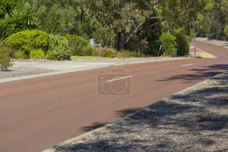 Street View of hilly Maidment Parade, Dalyellup, Australie-Occidentale avec le cyclisme, adjacent aux parcs régionaux de Kalgulup, et contenant les blocs spacieux de taille Ranch avec de grandes maisons et des arbres.