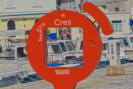 Téléchargez les photos : CRES, CROATIE - 25 avril 2020 : Tache rouge pour la photographie touristique à la vue côtière du port de la vieille ville avec des petits bateaux à moteur ancrés. - en image libre de droit