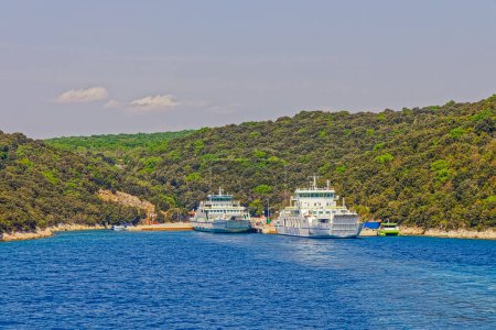 Photo for BRESTOVA, CROATIA - April 25 2020: View towards the ancored ferries from the leaving ferry that runs between Brestova and Porozina on Cres island. - Royalty Free Image