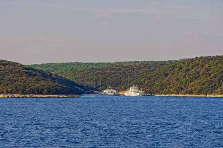 Photo for BRESTOVA, CROATIA - April 25 2020: View towards the ancored ferries from the leaving ferry that runs between Brestova and Porozina on Cres island. - Royalty Free Image