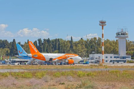 Foto de CORFU, GREECE, SEPTEMBER 27, 2019: Easyjet Airbus A319-111 and Tui Boeing in front of the control tower at the International Airport Ioannis Kapodistrias. - Imagen libre de derechos