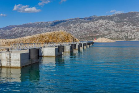 Foto de Equipment and parts of the Zigljen ferry port on the island of Pag ready to receive ferries and cruise ships. View towards the Velebit canal - Imagen libre de derechos