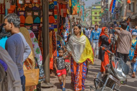 Foto de AJMER, INDIA - MARCH 3 2018: Colorful scene of mother with a child on the Dargah Bazar road of the old city center. - Imagen libre de derechos