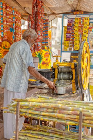 Foto de PUSHKAR, INDIA - MARCH 3 2018: Colorful scene of sugar cane juice seller seling on the street of the Holy City. - Imagen libre de derechos