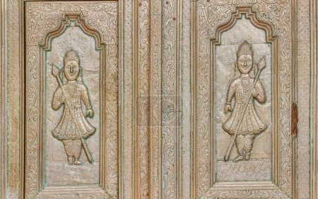 Téléchargez les photos : PUSHKAR, INDE - 3 MARS 2018 : Détail en relief de la porte d'entrée d'un homme gardant l'entrée du temple Parshuram Dwara Mandir. - en image libre de droit