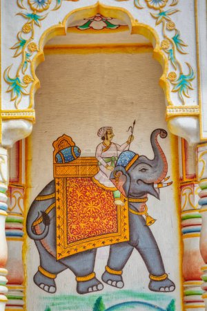Photo for PUSHKAR, INDIA - MARCH 3 2018: Colorful wall painting of a man riding elephant at the entrance to the Parshuram Dwara Mandir temple. - Royalty Free Image
