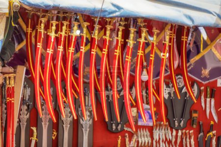 Foto de PUSHKAR, INDIA - MARCH 3 2018: Colorful scene of toy swords displayed on the street market of the Holy City. - Imagen libre de derechos