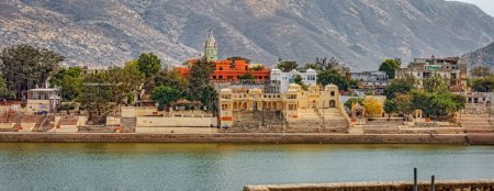 Foto de PUSHKAR, INDIA - MARCH 3 2018: Panoramic view from the house terrace to the temple and coast by the holly lake. - Imagen libre de derechos