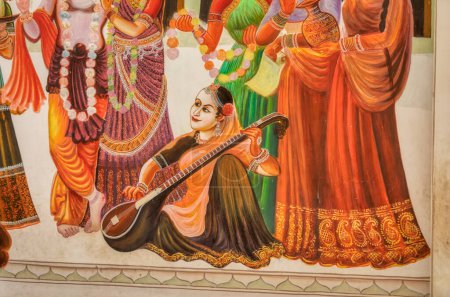 Foto de PUSHKAR, INDIA - 3 DE MARZO DE 2018: Pintura colorida en la pared de la calle del templo, detalle del jugador de tánpura femenino. - Imagen libre de derechos