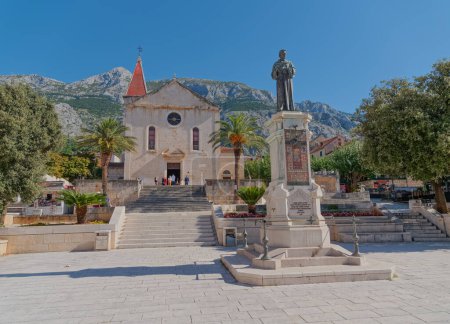 Photo for MAKARSKA, CROATIA - October 05, 2019 Monument to fra Andrija Kacic Miosic and church Saint Mark church at main square. - Royalty Free Image