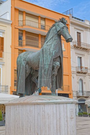 Foto de BARI, ITALIA - 26 de septiembre de 2019 Caballo con gualdrape de Mario Ceroli en el centro de la ciudad en Piazza della Liberta. El monumento está irónicamente dedicado solo al caballo.. - Imagen libre de derechos