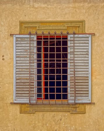 Foto de Ventana de calle estrecha con parrilla protectora y persianas en el centro histórico de Florencia Italia. - Imagen libre de derechos