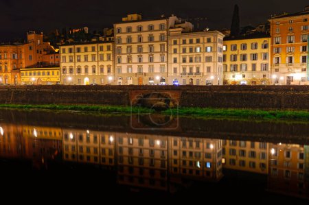 Foto de FLORENCIA, ITALIA - 25 de septiembre de 2019 Edificios antiguos con reflejo en el río Arno por la noche. - Imagen libre de derechos