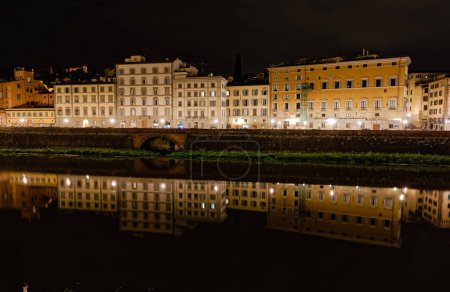Photo for FLORENCE, ITALY - September 25, 2019 Old buildings with reflection in Arno river by night. - Royalty Free Image
