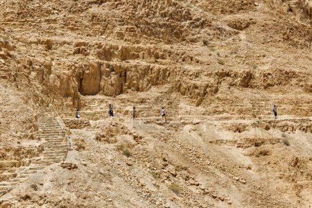 Foto de MASADA, ISRAEL - 21 DE MAYO DE 2016: Turistas en ruta de senderismo visitando las ruinas de Masada de la antigua fortaleza en el sur de Israel Desierto de Judea. - Imagen libre de derechos