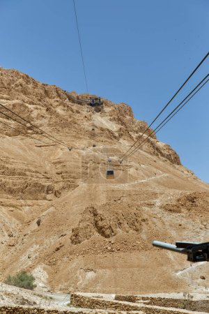 Photo for Tourists visiting Masada ruins by cable car in southern Judean desert Israel. - Royalty Free Image