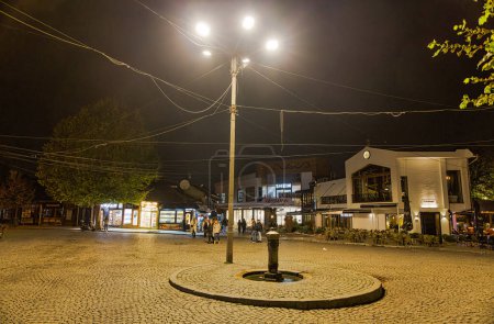 Photo for PRIZREN, KOSOVO - NOVEMBER 12, 2022: People walking by Shatervan square old fountain at cold november night. long exposure - Royalty Free Image